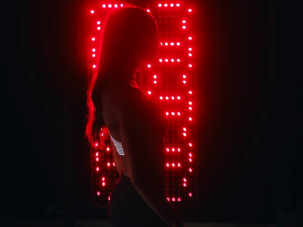 Woman standing in front of Red Light Therapy for Anti-Aging