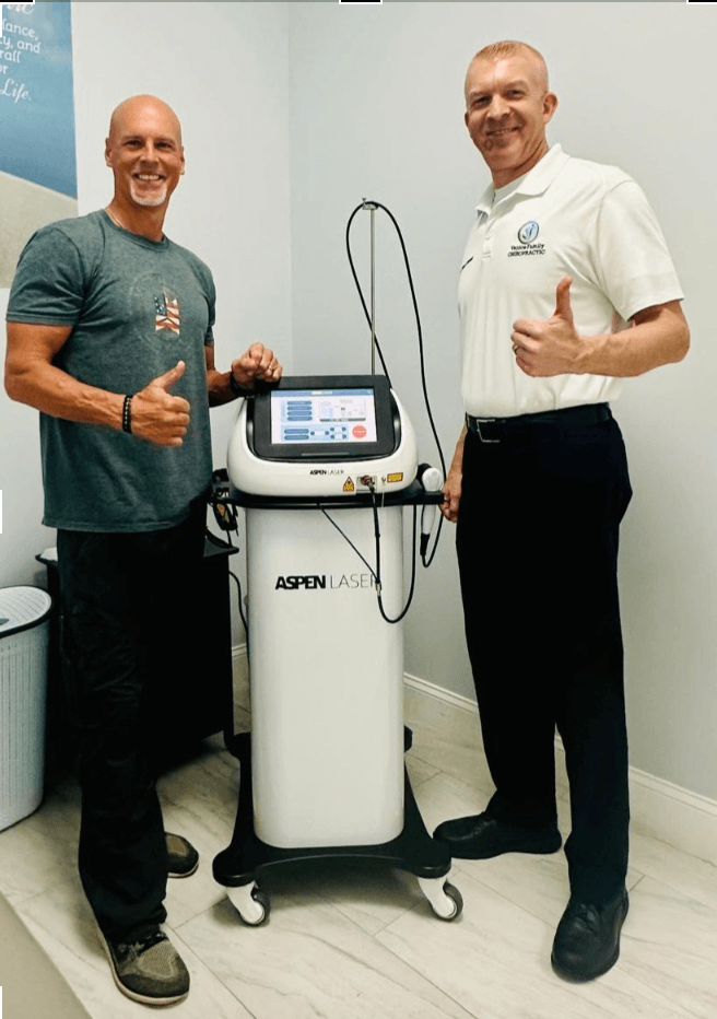 Aspen employee giving Aspen Laser maintenance tips to a new client with the Aspen Laser machine in between them