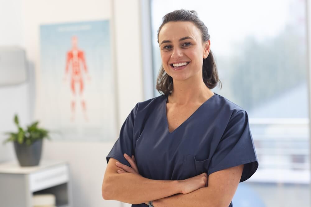Woman in scrubs standing in front of recovery technology